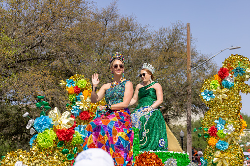 San Antonio, Texas, USA - April 8, 2022: The Battle of the Flowers Parade, Float Carrying the Cuchess of the festival wearing crowns and traditional dresses during the parade