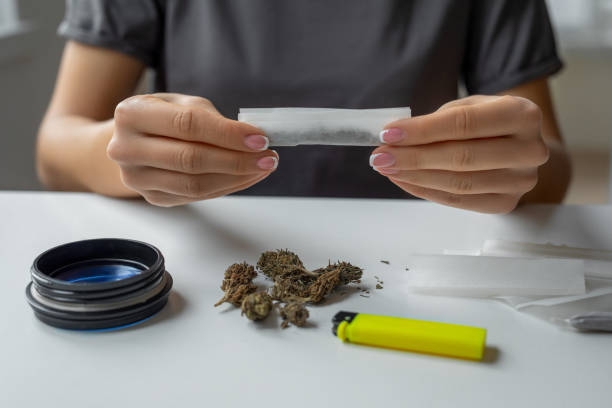 istock woman making cigarettes with marijuana 1472726469