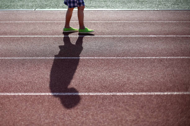 An Asian senior man is brisk walking exercise in stadium track.