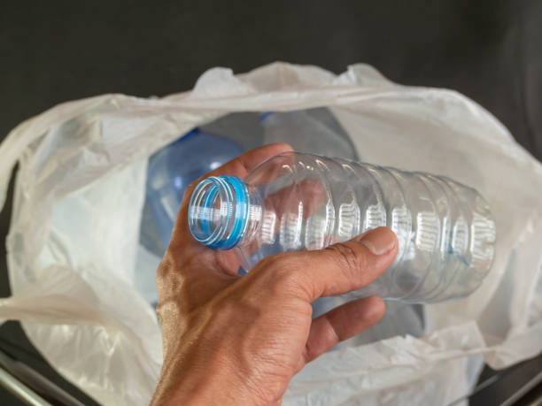 istock Human hands holding a water bottle are being thrown into plastic. 1472735925