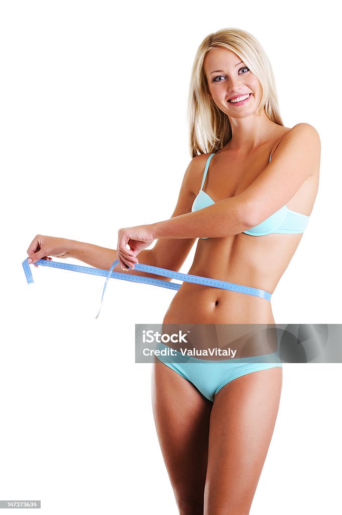 Beauty smiling girl measures the waist Happy cheerful woman with a beauty slim body measures the waist with measuring tape. Over white background. Adult Stock Photo