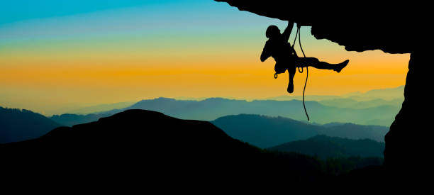 climb climber adventure panorama  background banner - black silhouette of climbers on a cliff rock with mountains landscape and sunset sunrise - wadi warning imagens e fotografias de stock