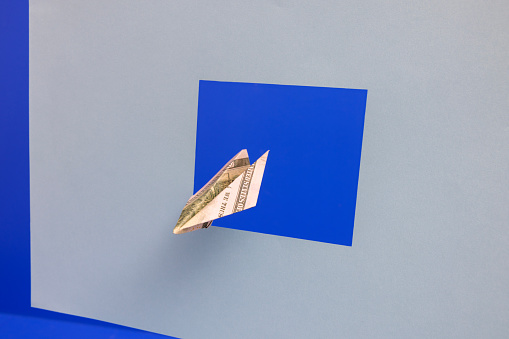 Paper airplane made of dollars is flying out
