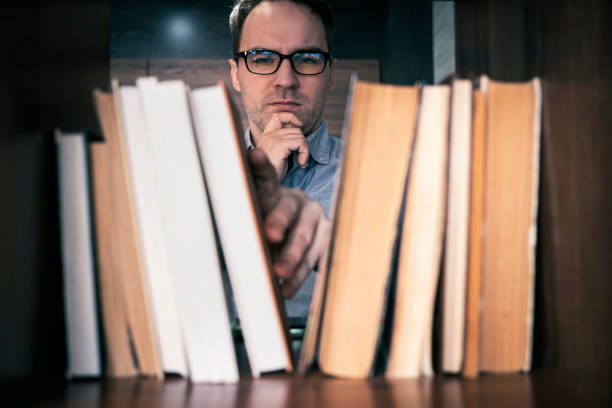 Young man sitting in modern bookstore ,library is tired