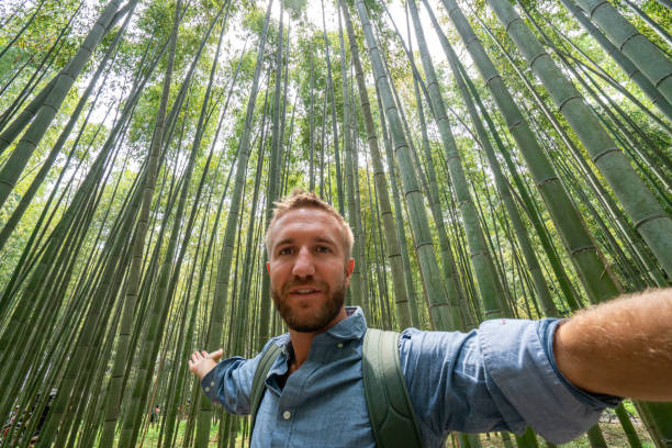 istock Young man taking selfie in bamboo forest in Japan 1472740333