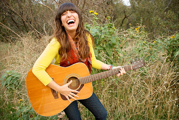 istock Young Woman Singing and Playing Guitar 147274048