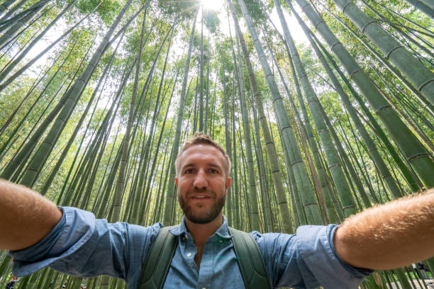Young man taking selfie in bamboo forest in Japan