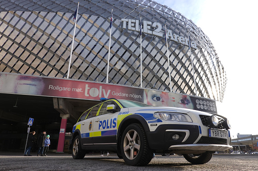 Police car parked outside Tele 2 Arena, on a sunny day in Stockholm, Sweden.