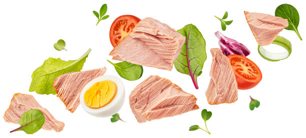 salade de thon tombante isolée sur fond blanc - tuna chunks photos et images de collection
