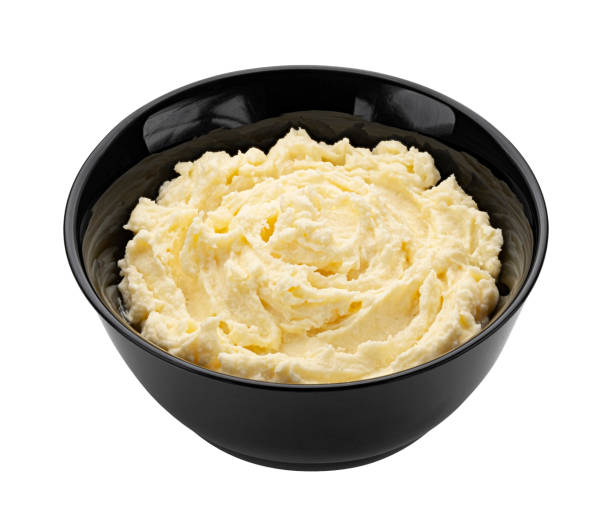istock Mashed potato in black bowl isolated on white background 1472744504