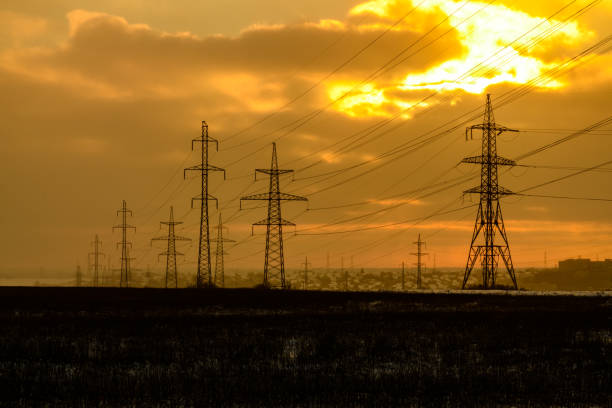 istock High voltage power line in a field at sunset on winter 1472744741