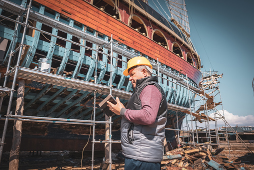 Engineer with project in digital tablet working inside a Shypyard