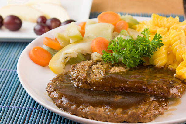 salisbury steak detail detail of salisbury steak patties with steam vegetables and spiral macaroni salisbury steak stock pictures, royalty-free photos & images