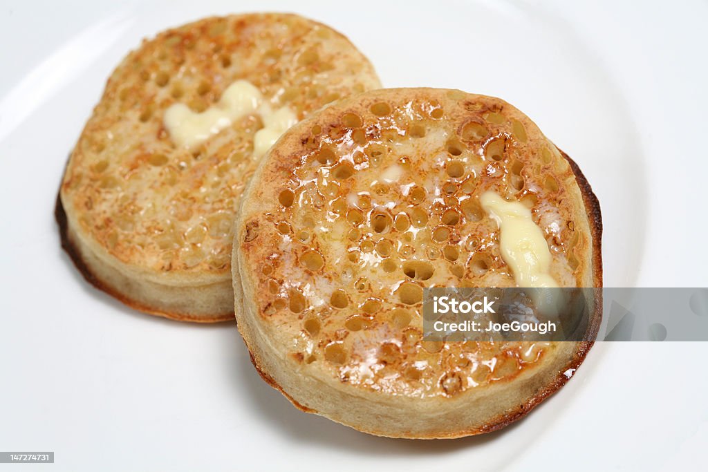 Buttered Crumpets Toasted English crumpets with melting butter (also known as pikelets in the Midlands and muffins in the North) Crumpet Stock Photo