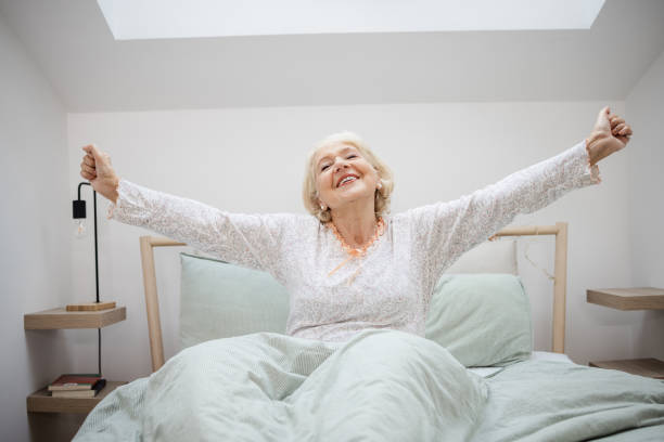 istock Senior woman stretching in bed 1472747562