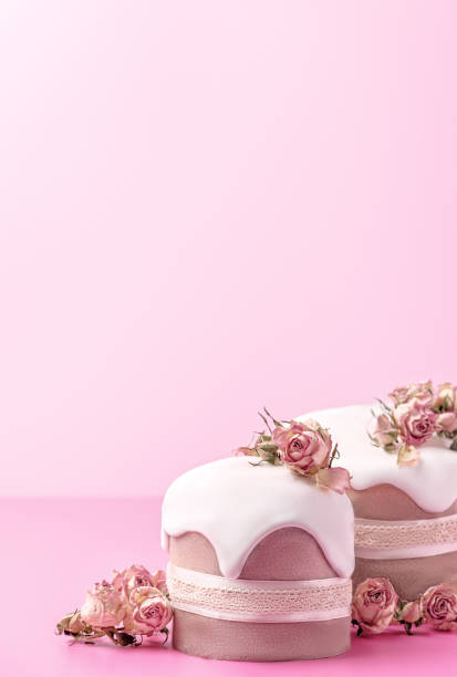 istock Glazed Easter cakes decorated with dry tea rose flowers on bright pink background. Easter composition with cakes, roses and chocolate eggs. 1472747577