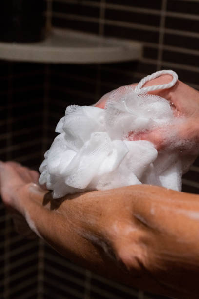 istock Soapy woman's arm in the shower. White sponge 1472749854
