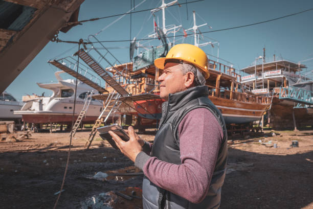 Commercial shipping tanker undergoing refurbishment, extensive renewal of hull and propulsion system, showcasing heavy industry, maritime commerce and specialized labor at shipyard facility.