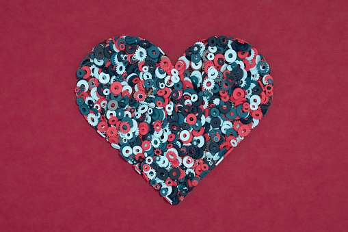Valentine's day background, two red hearts and satin scarlet ribbon on black crumpled silk, top view