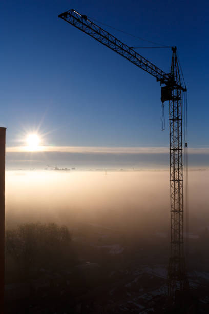 istock Construction crane in the fog at dawn 1472752263