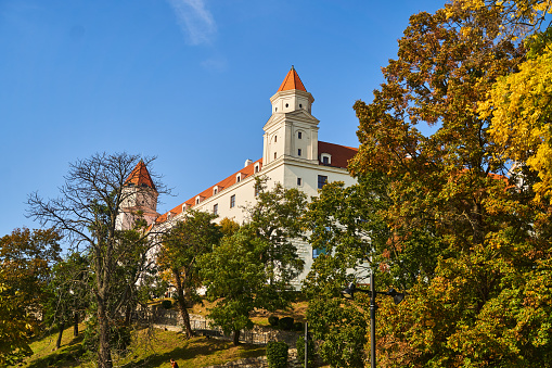 Slovakia, Bratislava - October 8, 2022: Bottom view of the white Bratislava castle among the trees in Slovakia. High quality photo