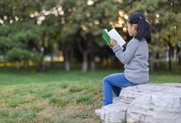 istock Little Girl Reading Book 1472754892