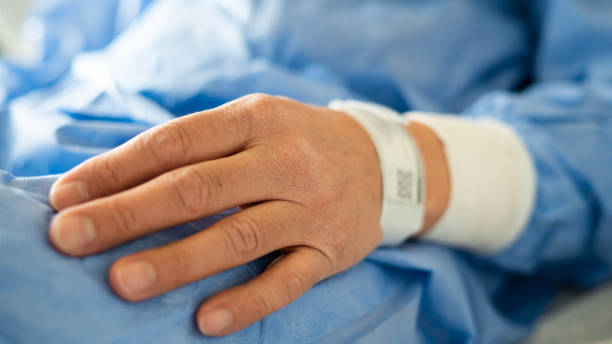 mano dell'uomo in primo piano con il braccialetto del paziente - braccialetto di identificazione foto e immagini stock