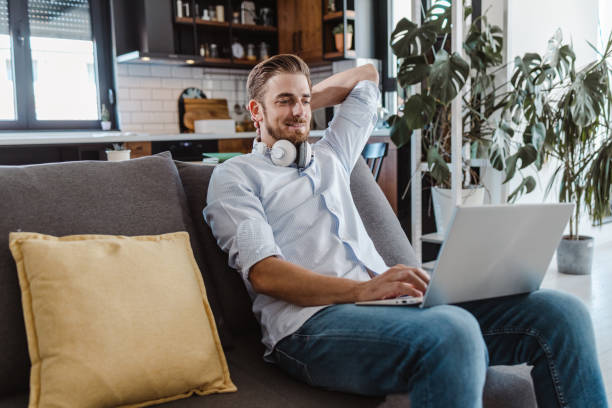 istock Relaxed young man using laptop at home 1472756660