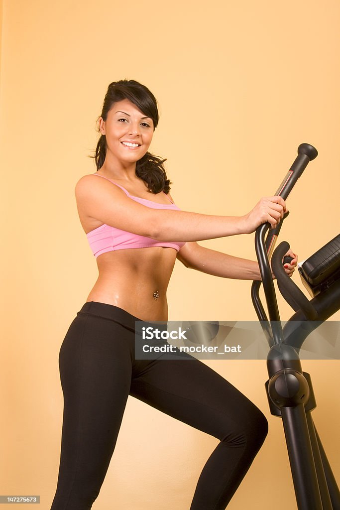 Attraente giovane donna facendo esercizi cardio - Foto stock royalty-free di Cross trainer
