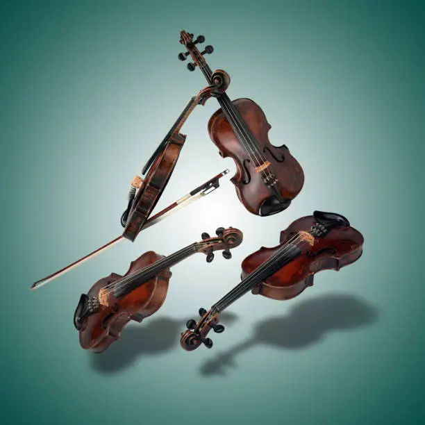 Photo of Floating Set of classical violin instrument  on green gradient