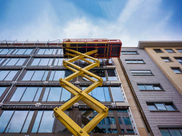 istock construction workers are mounting a modern building facade from an extended scissor lift. 1472758229