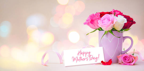 Mug with a heart, bouquet of roses and a tag with a text Happy Mothers Day stock photo