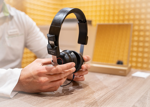 Audiologist holding a medical headset for audio testing in his office.