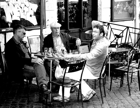 Rome, Italy_ July 2, 2009: Group of men playing chess in a sidewalk cafe, Rome, Italy..