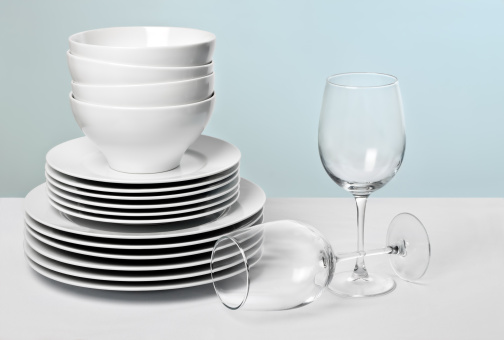 Blanco platos y cristal variedad de copas de vino sobre fondo azul photo