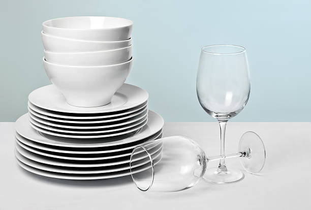 bianco piatti e bicchieri da vino in cristallo su diversi sfondo blu - dishware foto e immagini stock