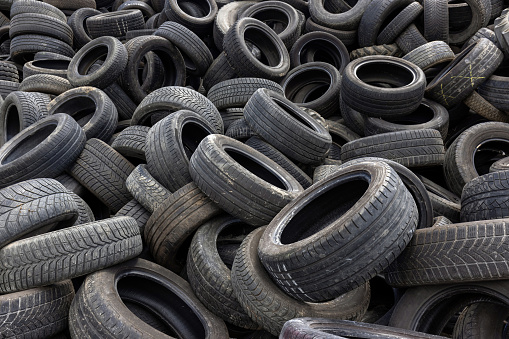 Waste disposal, a stack of end-of-life automobile and truck tires, close up shot. Recycle and environmental conservation concept.