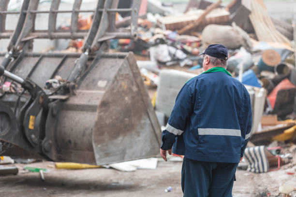 istock Man looking at garbage at landfill 1472761781