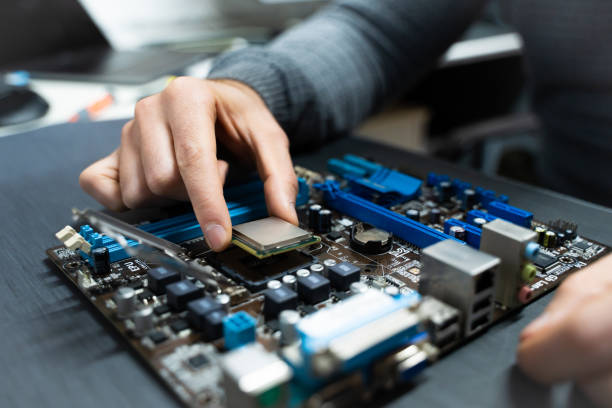 istock A man's hand picking up a cpu from a damaged computer motherboard. 1472764064