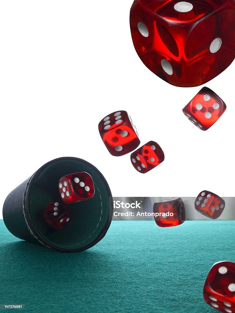 Dices and shaker Several red dices being thrown from the shaker. Flying over the green felt. Arts Culture and Entertainment Stock Photo