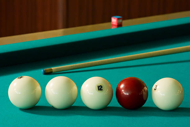 Billiard-balls and cue Four white billiard balls and a red ball with a cue at the green table number 12 pool ball ball number stock pictures, royalty-free photos & images