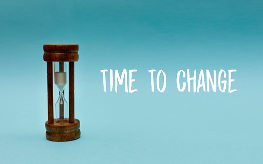 Time to change concept with hourglass on blue background as time passing concept. Life time passing. Meaning of life