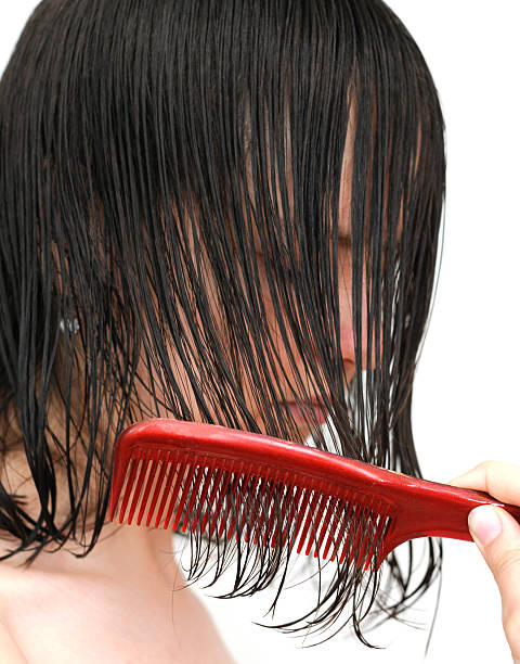 Girl with wet hair and comb A young woman combing her wet hair. wet hair stock pictures, royalty-free photos & images