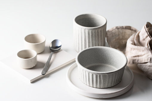 Nordic ceramic set,  bowls, plates, mugs in grey white colour with  linen napkin. Scandunavian style
