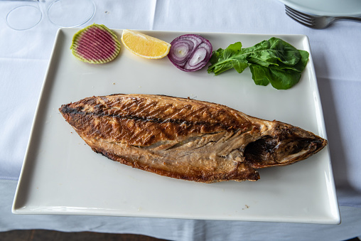 Plate of Atlantic bonito (palamut) fish with salad in Turkey.