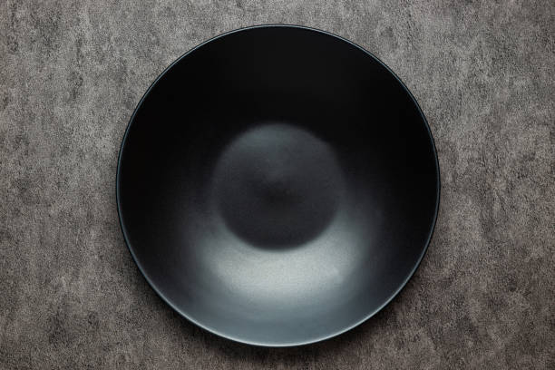 istock Empty black plate on gray concrete background. Top view image with copy space. 1472774172