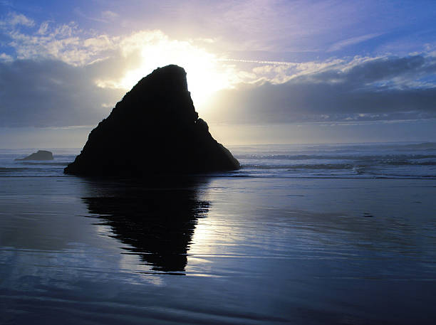 istock Sunset on beach behind rock outcrop 147277714