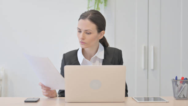 istock Young Businesswoman Working on Laptop and Documents 1472778317