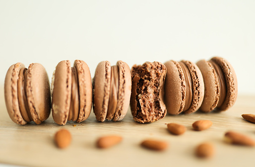Chocolate Macaroon cookies with almond nuts on wooden table, shallow focus