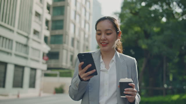 Businesswoman using Smart phone while walking, Handheld shot